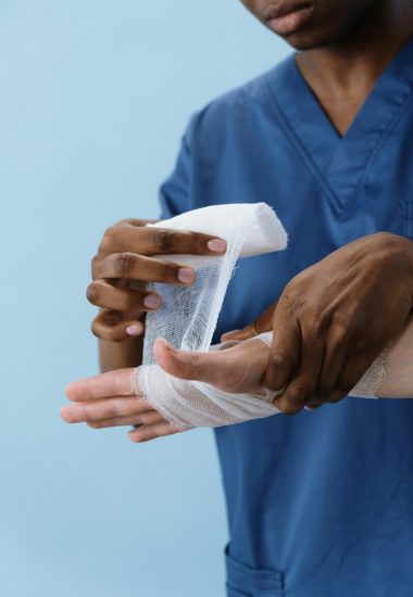 A physician gently wrapping a wound.